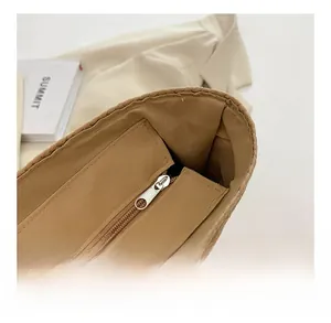 Détail de la fermeture éclair en métal et de la doublure intérieure du sac cabas en paille