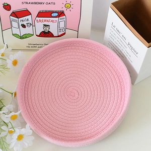Dettaglio del cesto portaoggetti in corda di cotone rosa intrecciata per la casa