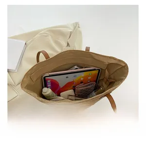 Vue intérieure du sac cabas en paille montrant la grande capacité pour tablette et maquillage