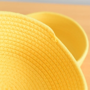 Macro shot of the yellow cotton rope basket showing spiral woven textures and stitching