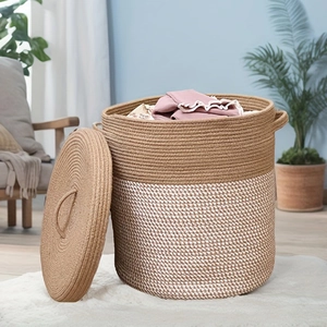 Detail of large woven cotton rope basket with dual-tone design and lid for home storage
