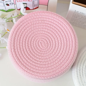Dettaglio ravvicinato della trama in corda di cotone rosa del cesto portaoggetti tondo