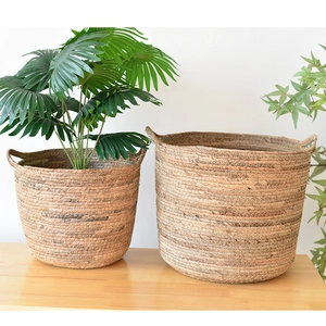 Detail view of handcrafted seagrass planter baskets showing natural woven textures and handles