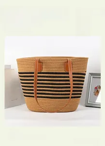 Detail of striped woven cotton tote with brown faux leather handles and decorative stitching