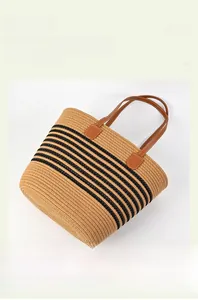 Detail view of the large capacity striped woven tote bag with brown leather handles