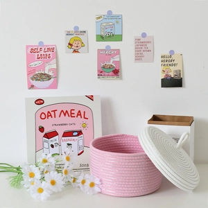 Dettaglio del cesto in corda di cotone intrecciato rosa e bianco con coperchio