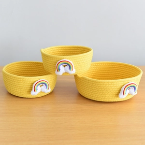 Detailed close-up of three yellow cotton rope baskets featuring rainbow embroidery