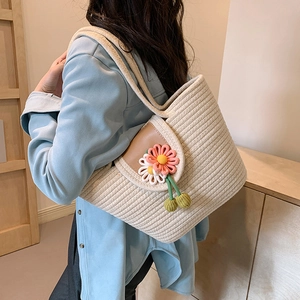 Bohemian woven straw tote bag with daisy accents and cotton rope texture on model