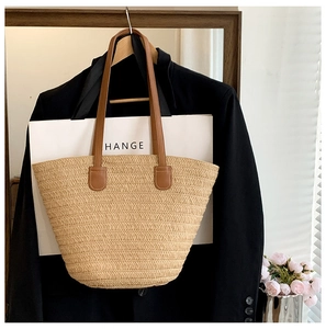 Détails de la texture en paille tressée et des poignées en cuir marron d'un sac cabas d'été