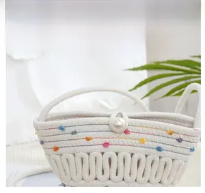 Detail of white woven bucket bag with colorful stitching and large pearl closure detail