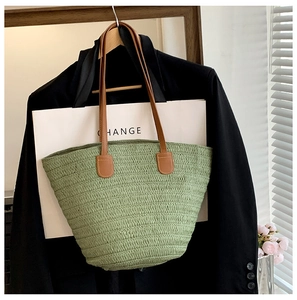 Détail du sac cabas tressé couleur vert herbe avec ses poignées en cuir synthétique