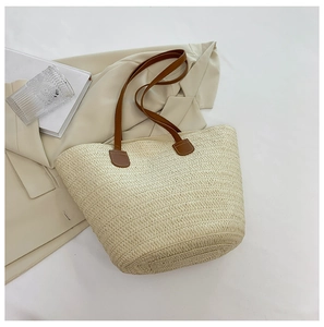 Détail du sac cabas en paille tressée avec anses en cuir marron pour l'été