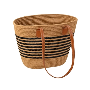Minimalist beige woven tote bag with black stripes and brown leather handles