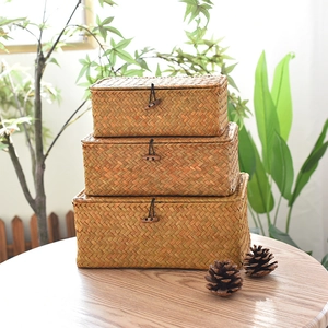 Close-up of three stacked handmade seagrass storage baskets with wood button closures