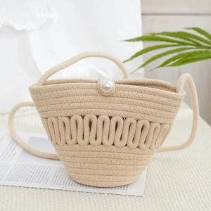 Handmade beige woven bucket bag with pearl closure and slender shoulder strap