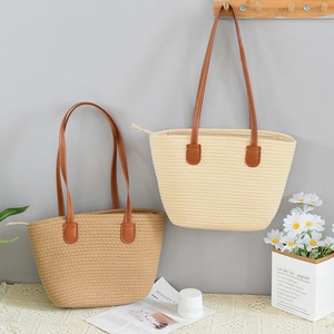 Detailed straw tote bag texture showing leather straps and secure zipper closure detail