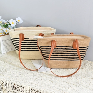 Detail of woven straw tote bags with black stripes and brown faux leather handles