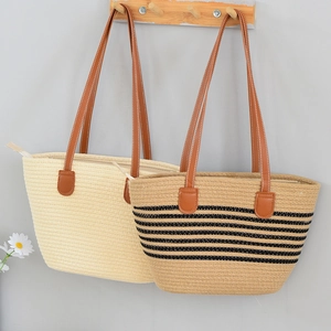 Detailed view of woven straw tote bags with brown leather straps and zip closure