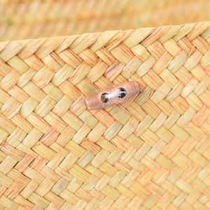 Detail of handmade seagrass storage box featuring twill weave and wooden toggle button