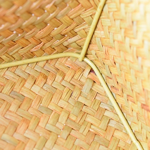 Detail view of woven seagrass basket showing internal metal frame and tight weave pattern