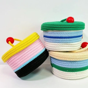 Three-piece set of nested woven cotton rope storage baskets with lids and handles