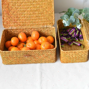 Detail of natural seagrass woven storage boxes with lids and rustic button closures