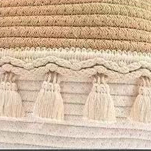 Detailed macro shot showing woven texture and decorative tassels on a bohemian laundry basket