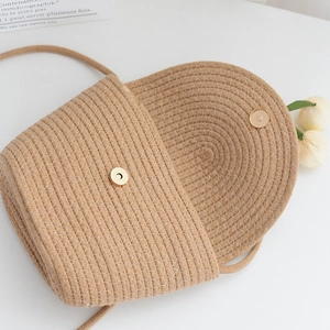 Vue détaillée du sac bandoulière en paille avec fermoir magnétique et tressage spiral