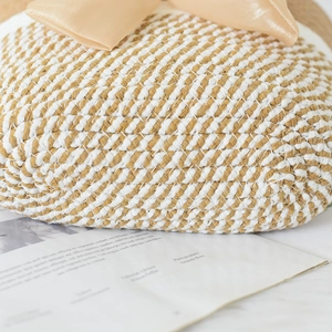 Close-up of woven straw handbag with twill pattern and a large satin bow detail