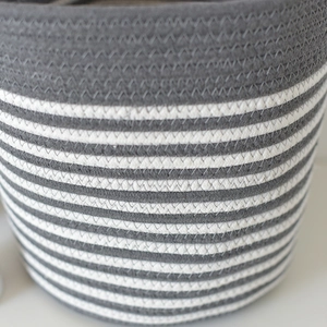 Close-up of woven cotton storage basket showing gray and white striped texture and stitching