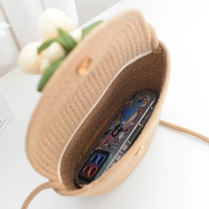 Détail d'un sac de téléphone en paille tressée avec décor de tulipes montrant l'intérieur