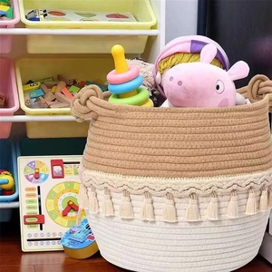 Handwoven cotton rope laundry basket with bohemian tassels and dual handles for toy storage