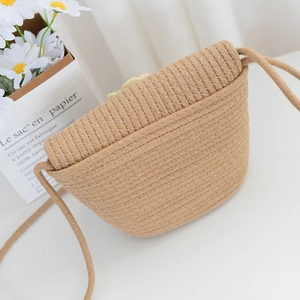 Détail du sac bandoulière en paille tressée avec texture en losange et longue bandoulière