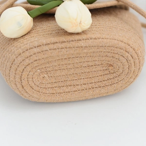 Détail du tissage en paille beige du sac d'été avec des décorations de tulipes blanches