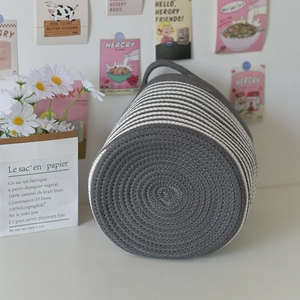 Detailed view of gray and white striped cotton rope woven basket with a durable handle
