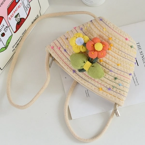 Detailed macro view of woven mini bucket bag featuring colorful 3D plush flower decorations
