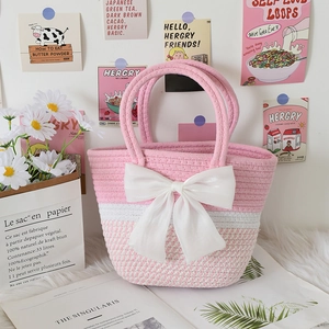Detailed texture of handwoven pink and white striped bag with a large cream silk bow