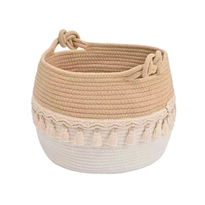 Woven cotton rope laundry basket with tassels and dual handles in boho style