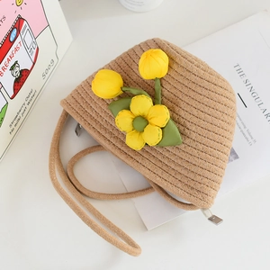 Detail of hand-woven beige mini bucket bag with yellow tulip floral decor and silver zipper