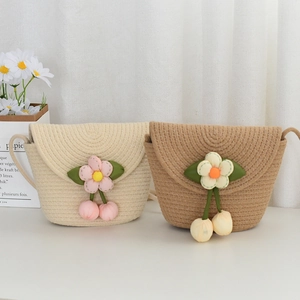 Détail de sacs bandoulière en paille pour filles avec fleurs 3D et breloques cerises