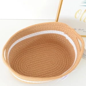 Detail of handwoven cotton rope storage basket with dual handles in a Nordic style