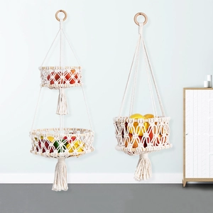 Detail of bohemian hand-woven cotton rope fruit baskets with wooden rings and tassels