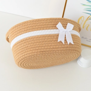 Detailed macro view of cotton rope woven storage basket with white ribbon bow decoration
