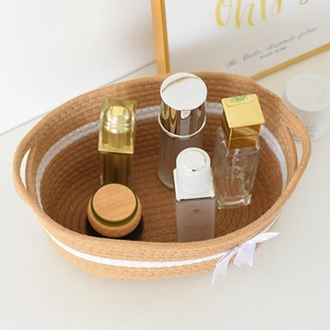 Detail of hand-woven cotton rope storage basket with decorative bow and cosmetics