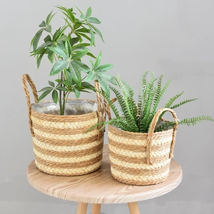 Close-up of two natural woven straw flower baskets with handles and waterproof liners