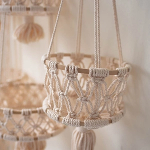 Close-up of Macramé hand-woven cotton rope basket with natural wood ring and long tassels