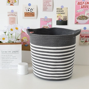 Detail of grey and white cotton rope storage basket featuring woven handles and soft texture