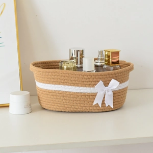 Close-up of woven cotton rope basket with brown and white stitching and silk bow detail
