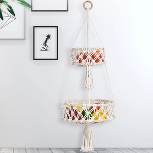 Detail of macrame woven double fruit basket with natural wooden rings and elegant long tassels