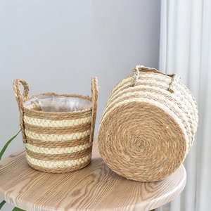 Close-up of handwoven seagrass flower basket with dual handles and waterproof inner lining